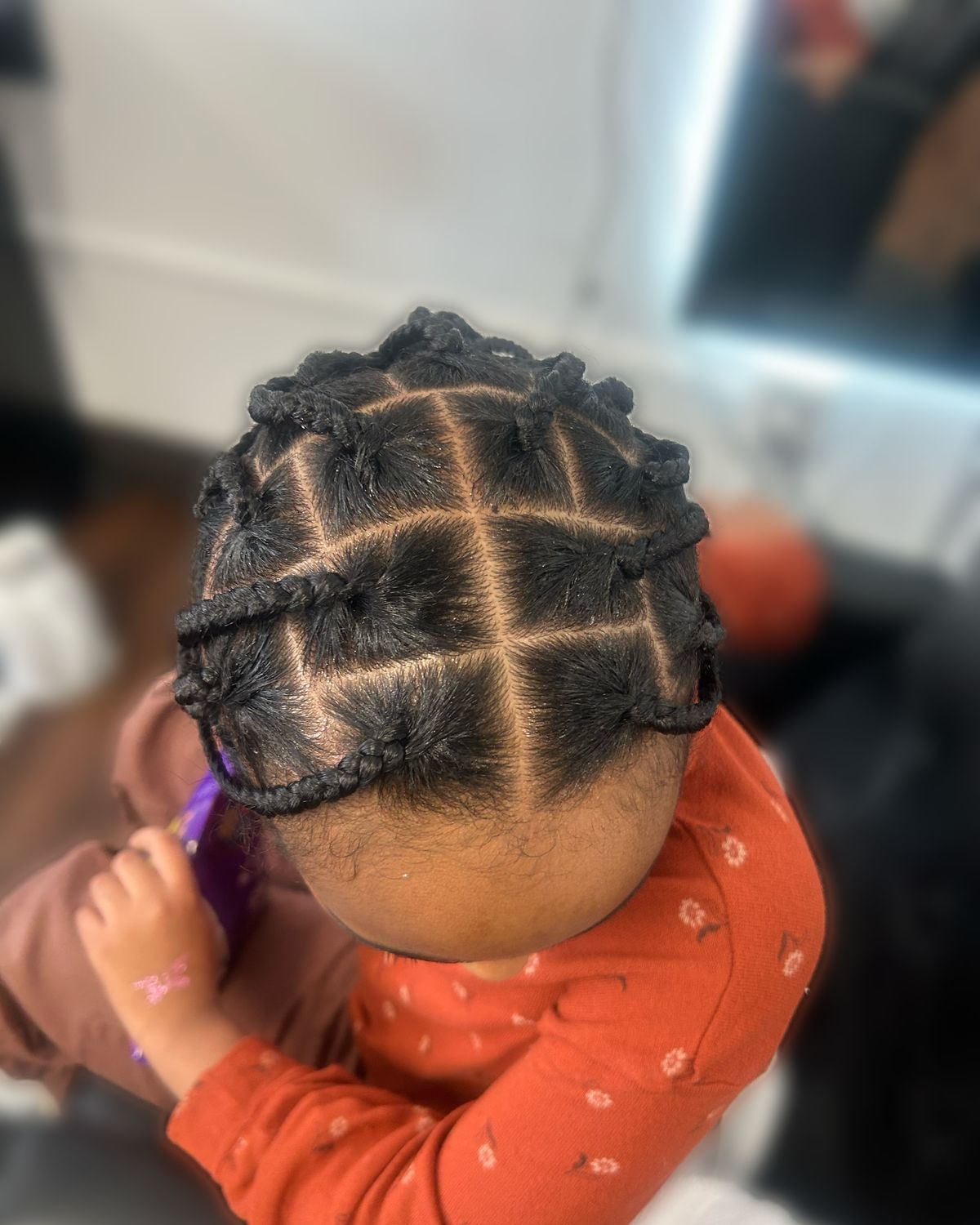 Child's cornrows in a criss-cross parted design