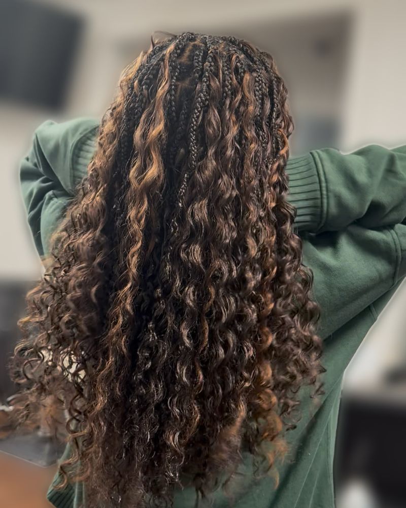 Long boho knotless braids with honey highlights and curly ends, seen from behind