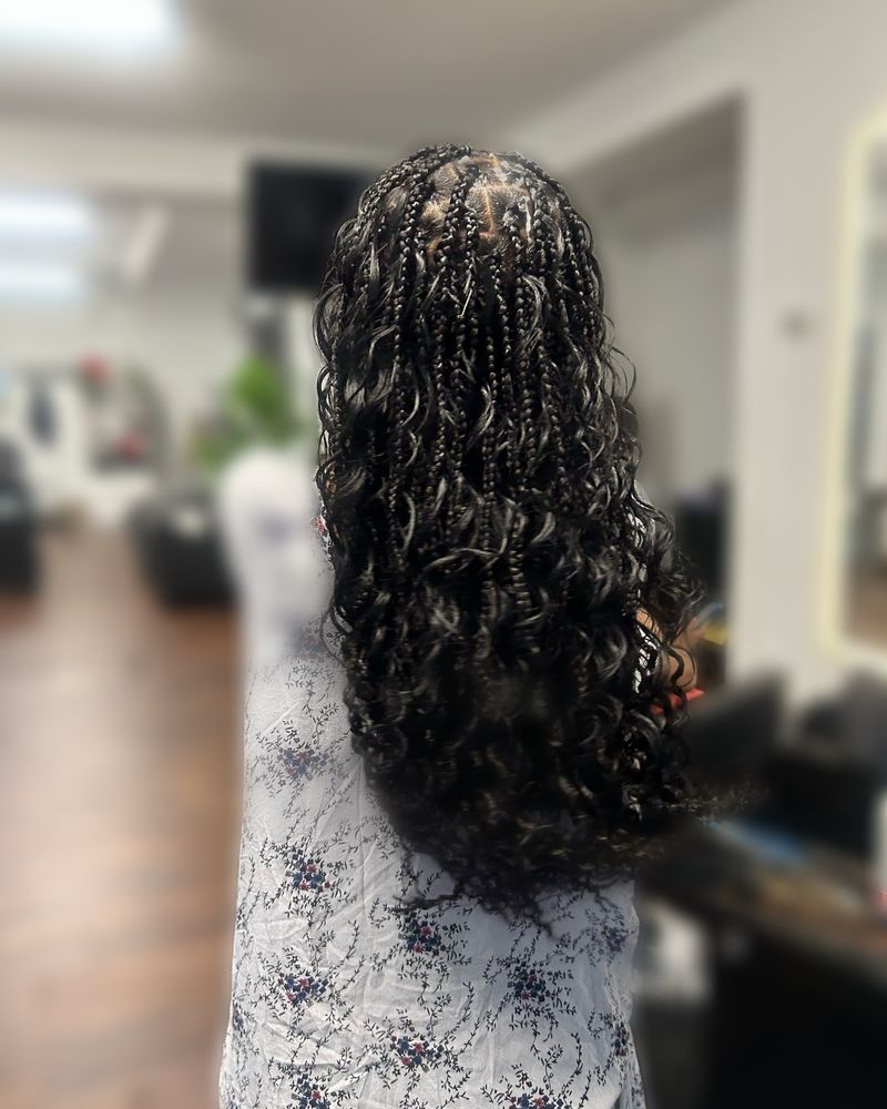 Long boho knotless braids with full curly ends, seen from behind