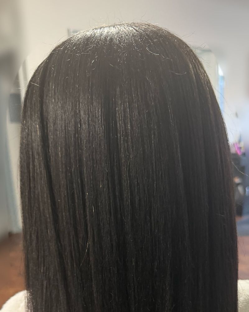 Sleek black silk press to mid-back, seen from behind