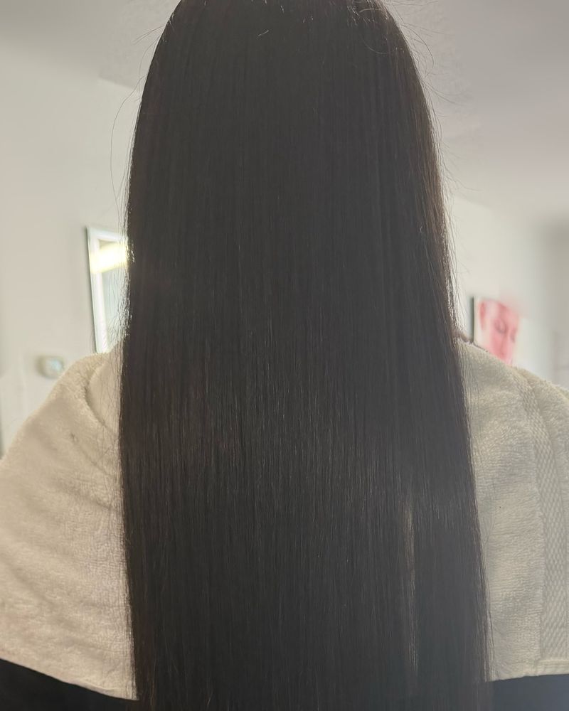 Very long, sleek silk press on dark hair, seen from behind